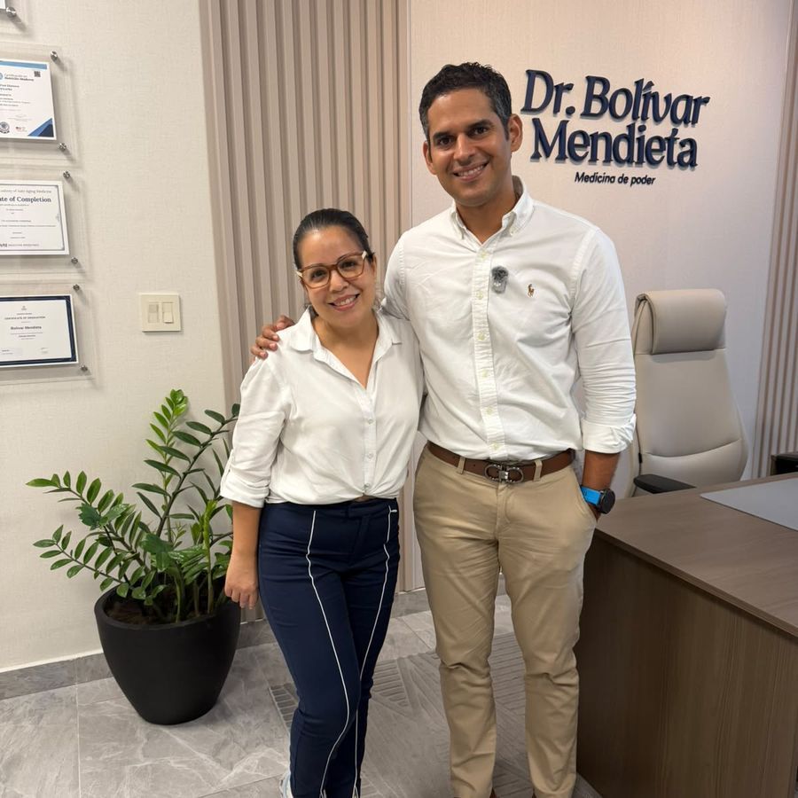 El Dr. Mendieta con una paciente frente a la pared de sus diplomas